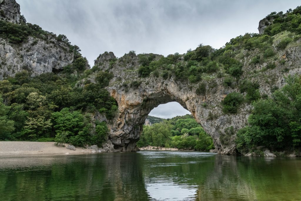 L'image représente le Pont d'Arc, arc rocheux surplombant la rivière Ardèche